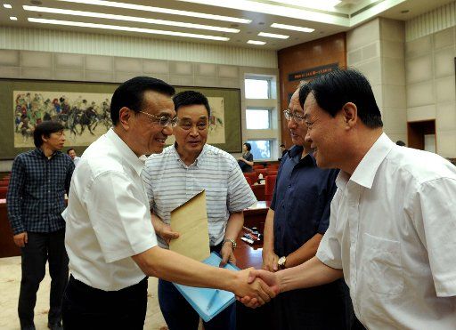 (140714) -- BEIJING, July 14, 2014 (Xinhua) -- Chinese Premier Li Keqiang shakes hands with a businessman during a symposium attended by the country\