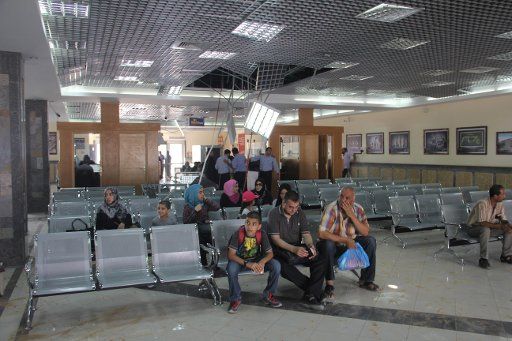(140825) -- GAZA, Aug. 25, 2014 (Xinhua) -- Palestinians, hoping to cross into Egypt, wait inside a passenger hall which was damaged by an Israeli air strike, at the Rafah border crossing with Egypt in the southern Gaza Strip city of Rafha, on ...