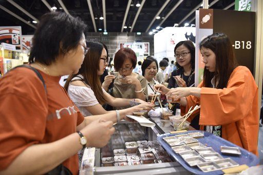 (140814) -- HONG KONG, Aug. 14, 2014 (Xinhua) -- Visitor try Japanese food during the 25th Food Expo in Hong Kong, south China, Aug. 14, 2014. The Expo kicked off on Thursday and visitors would be introduced to a huge range of food products by ...