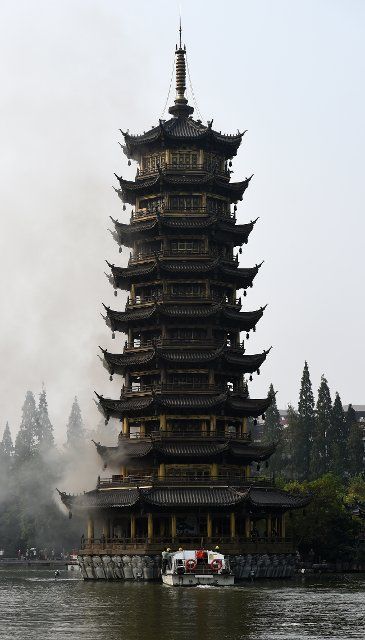(141001) -- GUILIN, Oct. 1, 2014 (Xinhua) -- Photo taken on Oct. 1, 2014 shows the "Sun Pagoda" which catches fire in the Fir Lake in Guilin, south China\