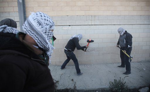 (141108) -- RAMALLAH, Nov. 8, 2014 (Xinhua) -- Palestinian activists demolish a section of Israeli apartheid wall viewing a highway between Jerusalem and Tel Aviv near Ramallah as they mark the 25th anniversary of Berlin wall memorial on Nov. 8, ...