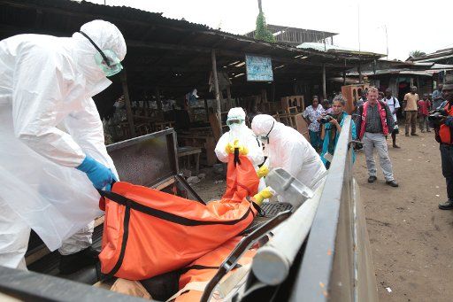 (141014) -- MONROVIA, Oct. 14, 2014 (Xinhua) -- Health workers load a body infected with Ebola virus onto a pickup truck in Monrovia, capital of Liberia on Oct. 14, 2014. (Xinhua\/Marcus DiPaola)