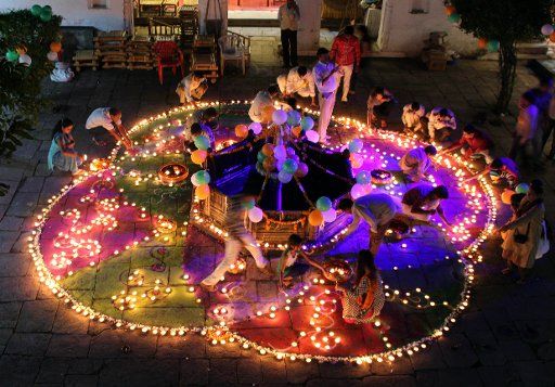 (141019) -- BHOPAL, Oct. 19, 2014 (Xinhua) -- People light earthen lamps during the celebration of Diwali ahead of the festival at Gauhar Mahal in Bhopal, India, Oct. 18, 2014. Diwali, or the festival of lights, will be celebrated across the country ...