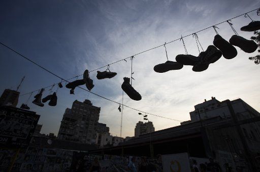 (141231) -- BUENOS AIRES, Dec. 31, 2014 (Xinhua) -- Shoes are hanging at the opening of a pedestrian pass in commemoration for the Cromanon tragedy occurred ten years ago, in Buenos Aires, Argentina, on Dec. 30, 2014. The 10th anniversary of the ...