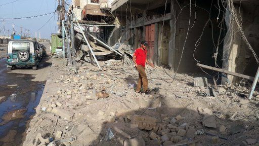 (150428) -- FALLUJAH, April 28, 2015 (Xinhua) -- A man stands by a damaged building after Iraqi Air Force\