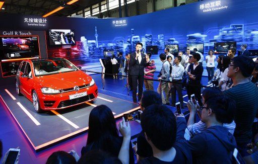 (150527) -- SHANGHAI, May 27, 2015 (Xinhua) -- Visitors take pictures around an exhibition stand of an automobile manufacturer at the 2015 International Consumer Electronics Show (CES) Asia in east China\