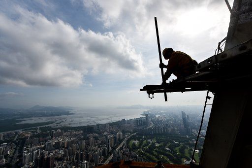 (150703) -- SHENZHEN, July 3, 2015 (Xinhua) -- A worker braves the scorching heat as he dismantles scaffold on the top of the PingAn International Financial Center in Shenzhen, south China\