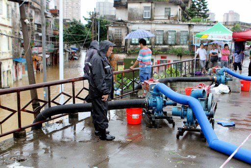 (150729) -- QINZHOU, July 29, 2015 (Xinhua) -- Workers use water pumps to drain water on Zhongshan Road in Qinzhou City, south China\