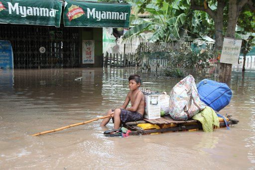 (150803) -- KALAY, Aug. 3, 2015 (Xinhua) -- A boy on a makeshift raft paddles his way through a flooded area in Kalay township of Sagaing Region, Myanmar, Aug. 3, 2015. Heavy monsoon rains have left at least 47 people dead and affected more than 210,...