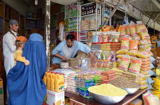 (150711) -- KUNDUZ, July 11, 2015 (Xinhua) -- An Afghan woman with a baby in her arms buys dry fruits in a shop ahead of the Eid al-Fitr festival which marks the end of the holy Islamic month of Ramadan in Kunduz province, northern Afghanistan, July ...