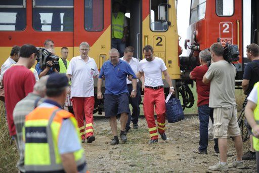 (150816) -- BUDAPEST, Aug. 16, 2015 (Xinhua) -- Rescuers escort an injured man from a train in Acsa, northern Hungary, Aug. 16, 2015. Two commuter trains collided head-on 50 km northeast of the Hungarian capital on Sunday, leaving 10 people injured, ...