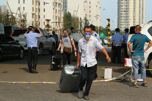 (150817) -- TIANJIN, Aug. 17, 2015 (Xinhua) -- Residents carrying their belongings walk out of a community near the warehouse explosion site in Tianjin, north China, Aug. 17, 2015. Residents of the community returned home to fetch belongings on ...