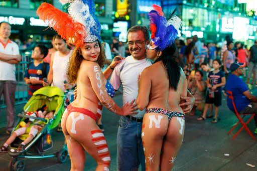 (150822) -- NEW YORK, Aug. 22, 2015 (Xinhua) -- Two women wearing body paint and underwear pose for a photo with a man at New York\