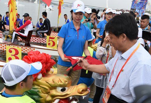 (150808) -- ORDOS, Aug. 8, 2015 (Xinhua) -- Tan Jingfeng (R front), deputy secretary general of the organizing committee of the 10th National Traditional Games of Ethnic Minorities of China, attends an eye drawing ceremony of the dragon boats race ...