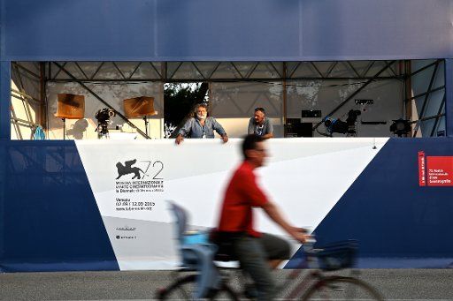 (150901) -- VENICE, Sept. 1, 2015 (Xinhua) -- Camera men take a rest after they set up their working area in front of the venue of the 72nd Venice Film Festival in Venice, Italy, on Sept.1, 2015. The 72nd Venice Film Festival will kick off in Lido ...
