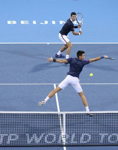 (151008) -- BEIJING, Oct. 8, 2015 (Xinhua) -- Novak Djokovic of Serbia and his younger brother and teammate Djordje Djokovic (front) play against Jack Sock of the United States and Vasek Pospisil of Canada during the men\