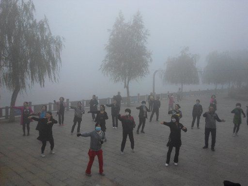(151006) -- PINGQUAN, Oct. 6, 2015 (Xinhua) -- Residents wearing masks do morning exercises amid mist and smog in the county seat of Pingquan, north China\