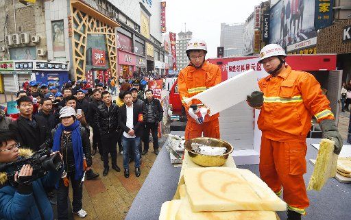 (151108) -- ZHENGZHOU, Nov. 8, 2015 (Xinhua) -- Firefighters introduce the difference between inflammable and non-inflammable construction materials to citizens in Zhengzhou, central China\