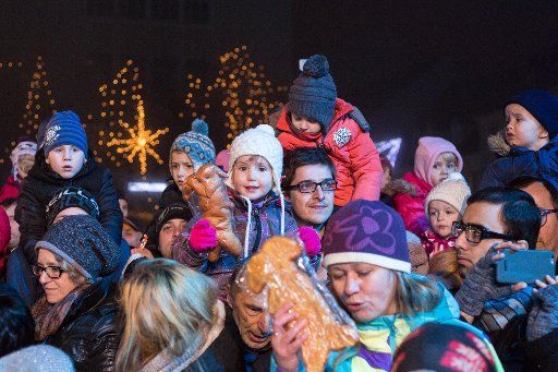 (151206) -- LJUBLJANA, December 6, 2015 (Xinhua) -- Children receive traditional Krampus-shaped bread during the annual St. Nicholas procession in Ljubljana, Slovenia, Dec. 5, 2015. The first of three good men (St.Nicholas, Santa Claus and Father ...
