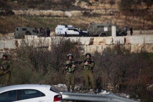 (151211) -- HEBRON, Dec. 11, 2015 (Xinhua) -- Israeli security forces stand at the scene of an alleged attack at Halhul checkpoint near the West Bank city of Hebron, Dec. 11, 2015, after troops shot and killed a Palestinian man who attempted to ram ...