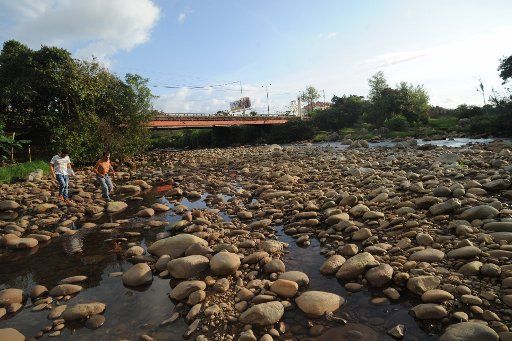 (160117) -- CAUCA, Jan. 17, 2016 (Xinhua) -- Undated image shows two men jumping on the rocks in the Cauca River which evidence its flow loss, on its way by the city of Popayan, capital of Cauca department, Colombia. Although rains have been ...