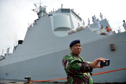 (160124) -- JAKARTA, Jan. 24, 2016 (Xinhua) -- An indonesian soldier takes a photo in front of Chinese naval missile destroyer Ji\