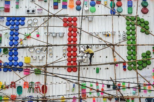 (160317) -- JAKARTA, March 17, 2016 (Xinhua) -- A worker arranges assorted commodities on the wall outside a store in West Jakarta, Indonesia, March 17, 2016. The exterior of the store was decorated with various of commodities that laid out nicely ...