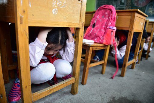 (160509) -- HEFEI, May 9, 2016 (Xinhua) -- Students hide themselves under desks during an emergency drill in Huangshan Road Primary School in Hefei, capital of east China\