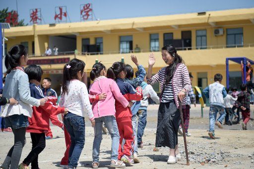 (160517) -- FENGTAI, May 17, 2016 (Xinhua) -- Li Yuanfang plays with pupils at Zhangxiang Elementary School in Dingji Town of Fengtai County, east China\
