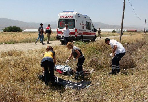 (160620) -- ANKARA, June 20, 2016 (Xinhua) -- Medical workers and a policeman work near the dead bodies after a train hit a minibus in Turkey\