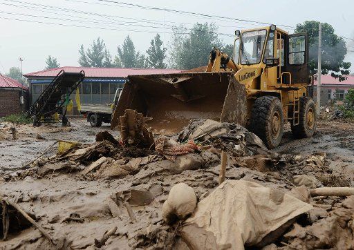 (160725) -- SHIJIAZHUANG, July 25, 2016 (Xinhua) -- An excavator clears away mud in Nanshitun village of Xingtai City, north China\