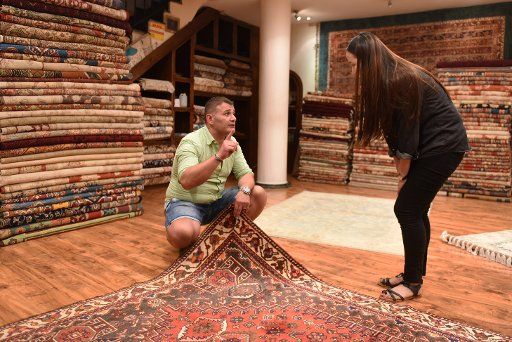 (160818) -- ISTANBUL, Aug. 18, 2016 (Xinhua) -- Businessman Cemhur Yasa displays a carpet at his carpet shop in the Grand Bazaar in Istanbul, Turkey, on Aug. 17, 2016. Turkey\