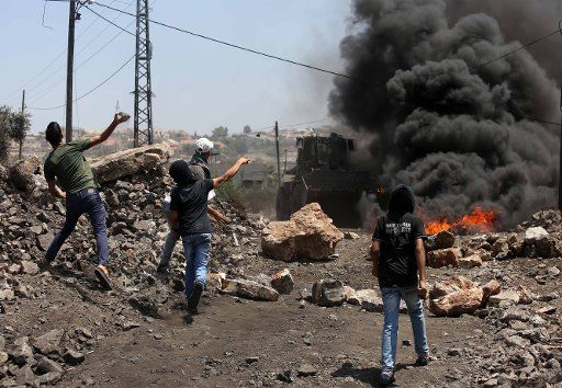 (160812) -- NABLUS, Aug. 12, 2016 (Xinhua) -- Palestinian protesters hurl stones at an Israeli soldier during clashes after a protest against the expansion of Jewish settlements in Kufr Qadoom village near the West Bank city of Nablus, on Aug. 12, ...