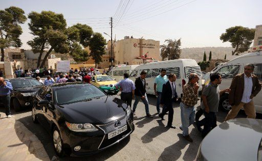 (160925) -- AMMAN, Sept. 25, 2016 (Xinhua) -- People gather in front of a hospital where the body of Jordanian writer Maher Hattar, who was shot dead, was held in Amman, Jordan, Sept. 25, 2016. The Jordanian writer who published a cartoon that some ...