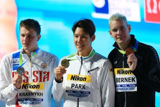 (161207) -- WINDSOR , Dec. 7, 2016 (Xinhua) -- Gold medalist Park Taehwan (C) of South Korea, silver medalist Aleksandr Krasnykh (L) of Russia and bronze medalist Peter Bernek of Hungary pose for photos during the awarding ceremony of the Men\