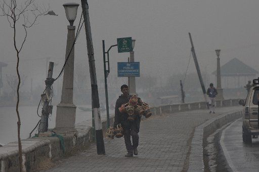 (161130) -- SRINAGAR, Nov. 30, 2016 (Xinhua) -- A Kashmiri man carries traditional fire pots, or Kangris, as he walks on the bank of Dal Lake during a cold day in Srinagar, summer capital of Indian-controlled Kashmir, Nov. 30, 2016. The temperature ...