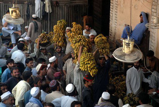 (170501) -- PESHAWAR, May 1, 2017 (Xinhua) -- Pakistani laborers carry piles of bananas at a fruit and vegetable market on the International Workers\