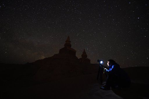 (170518) -- EJIN, May 18, 2017 (Xinhua) -- A photographer takes photos of Khara-Khoto under the starry sky in Ejin Banner, north China\