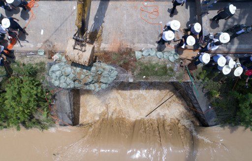 (170703) -- CHANGSHA, July 3, 2017 (Xinhua) -- A crane carries sandbags to block off water after a discarded trailer plugs up a culvert on the Weishui River in Changsha, capital of central China\