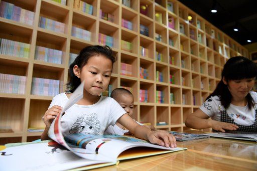 (170819) -- FEIXI, Aug. 19, 2017 (Xinhua) -- Local residents read books in a book bar at a community in Feixi County, east China\