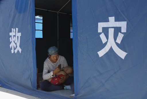 (170809) -- JINGHE, Aug. 9, 2017 (Xinhua) -- Quake-affected people rest in a relief tent at a temporary settlement in Jinghe County, northwest China\