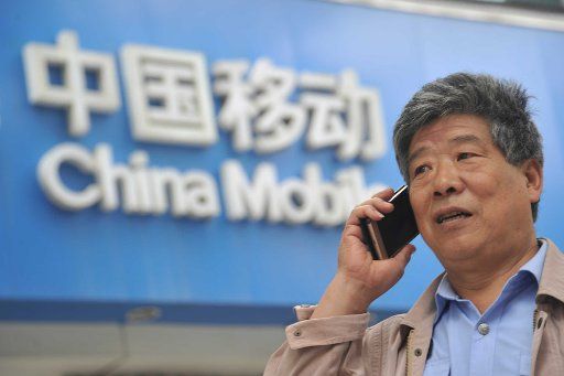 (170831) -- YUNCHENG, Aug. 31, 2017 (Xinhua) -- A man makes a call with his mobile phone in front of a service hall of China Mobile in Xinjiang County of Yuncheng City, north China\