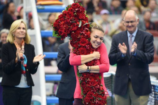 (171007) -- BEIJING, Oct. 7, 2017 (Xinhua) -- Simona Halep of Romania celebrates after being presented with a bouquet in the shape of the number \