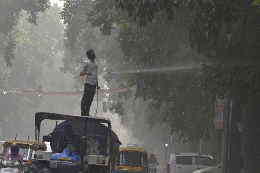 (171109) -- NEW DELHI, Nov. 9, 2017 (Xinhua) -- A municipal worker sprays water on the tree to settle dust as a measure against ongoing heavy pollution in the air in New Delhi, India on Nov. 9, 2017.(Xinhua\/Sarkar)(rh)
