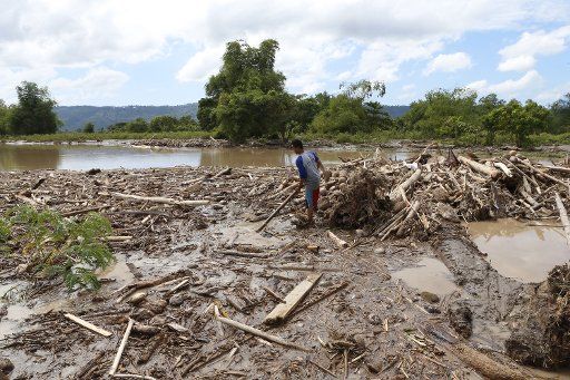 (171224) -- LANAO DEL NORTE, Dec. 24, 2017 (Xinhua) -- A man searches for missing people in Lanao del Norte Province, the Philippines, on Dec. 24, 2017. The death toll from mudslides and flooding triggered by tropical storm Tembin has risen to 200, police said here late Saturday night. (Xinhua\/Stringer) (swt)