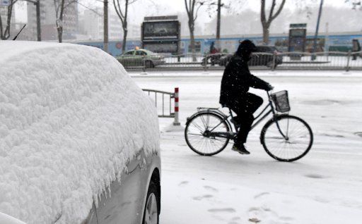 (180104) -- ZHENGZHOU, Jan. 5, 2018 (Xinhua) -- A man rides on the snow-covered Huayuan Road in Zhengzhou, capital of central China\