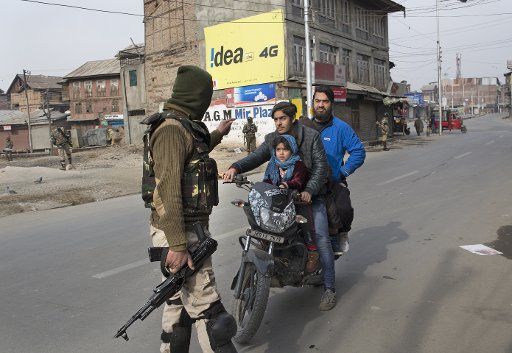(180128) -- SRINAGAR, Jan. 28, 2018 (Xinhua) -- An Indian paramilitary trooper stops a motorcyclist during restrictions to prevent protests against civilian killings, in Srinagar city, the summer capital of Indian-controlled Kashmir, Jan. 28, 2018. At least two civilians were killed and one wounded Saturday after Indian troops fired upon protesters in restive Indian-controlled Kashmir, police said. (Xinhua\/Javed Dar) (lrz)