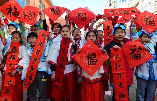 (180205) -- CANGZHOU, Feb. 5, 2018 (Xinhua) -- Pupils of Chinese calligraphy hobby group present spring festival couplets written by themselves at a community in Cangzhou, north China\