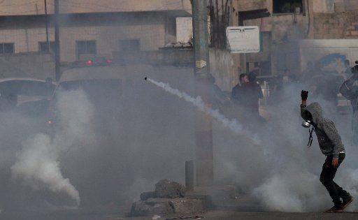 (180217) -- NABLUS, Feb. 17, 2018 (Xinhua) -- A Palestinian protester throws back a tear gas canister fired by Israeli soldiers during clashes, following a protest against Jewish settlements in Bita village near the West Bank city of Nablus, Feb. 16, 2018. (Xinhua\/Nidal Eshtayeh) (zjy)