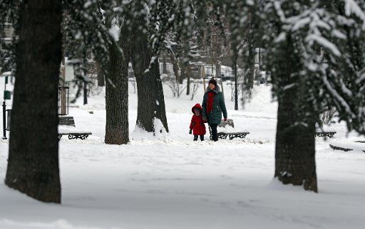 (180227) -- BELGRADE, Feb. 27, 2018 (Xinhua) -- A woman and a child walk through snow-covered park in Belgrade, Serbia on Feb. 27, 2018. (Xinhua\/Predrag Milosavljevic)(rh)
